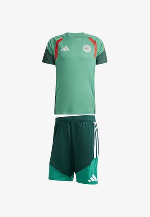 Camiseta de fútbol verde con acentos rojos y verde oscuro y pantalones cortos a juego con rayas blancas y logo de Adidas, aislados sobre fondo blanco.