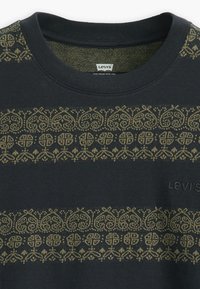 Sudadera negra con un patrón decorativo en verde oliva que presenta remolinos y formas en el pecho. Marca Levi's en color a juego.