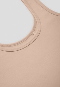 Jasno-beżowy top na ramiączkach z okrągłym dekoltem i wąskimi ramiączkami, wykonany z gładkiego, elastycznego materiału. Subtelne przeszycie wokół dekoltu.