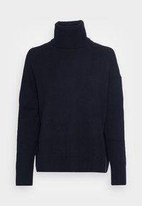 Navyblauwe coltrui met een ontspannen pasvorm, geribbelde textuur bij de kraag en manchetten, en verlaagde schouders. Gebreide stof met lichte rek.