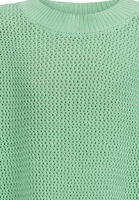 Minzgrüner gestrickter Pullover mit strukturiertem Muster und geripptem Kragen. Der Stoff wirkt weich und atmungsaktiv mit einem lockeren Schnitt.