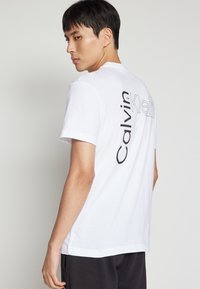 Calvin Klein ANGLED BACK LOGO - Apdrukāts T-krekls - bright white