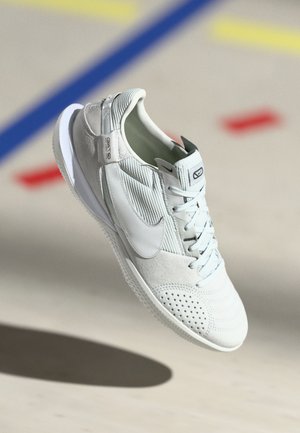 Nike spordijalatsid helesinises hallis, millel on nahk ja võrkkangas, sisseehitatud perforatsioonid, valge tald ja hõbedane aktsent kanna juures.