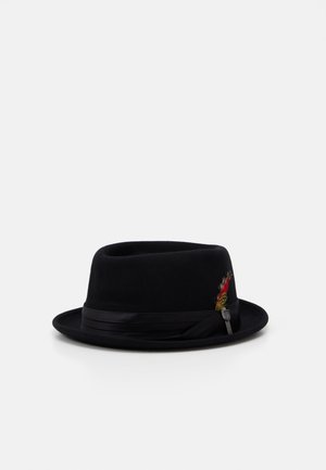 Sort fedora-hat med sort bånd og en lille dekorativ rød og gul fjer i siden, vist på hvid baggrund.