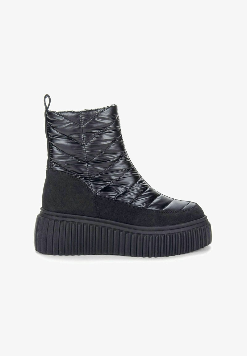 Black ankle boot featuring a quilted glossy upper, suede accents, and a thick ridged platform sole. Back pull tab for easy wear.