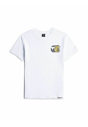 T-shirt blanc à manches courtes avec une petite illustration d'une radio vintage jaune et grise émettant des notes de musique sur la poitrine gauche.