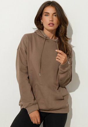 Bruine hoodie met een kangoeroezak, verstelbare koordjes en ribbelmanchetten. Zachte stof, relaxte pasvorm, minimale details.