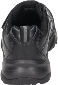 Scarpa da ginnastica nera con una tomaia in pelle texture, colletto imbottito e una linguetta in tessuto sul tallone. Presenta una striscia grigia a contrasto sul tallone.