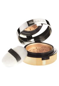 Poudre compacte dans un boîtier rond en métal avec un couvercle argenté brillant, des accents dorés et un puff applicateur doux et blanc avec une sangle noire.