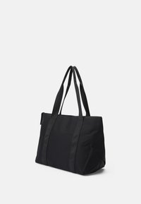Sac fourre-tout noir en tissu durable, avec deux larges poignées, un compartiment principal spacieux et une forme structurée avec une texture lisse.