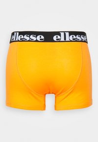 Oranži bokseršortas, kas izgatavots no mīkstas auduma ar melnu elastīgu jostasvietu, kurā ir logo "ellesse". Gluda tekstūra un pieguļošs dizains.
