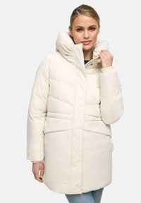 Manteau en duvet blanc avec un col haut, des coutures géométriques et des poches avant. Le tissu semble lisse et isolé, adapté aux temps froids.
