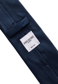 Marinblått texturerat slips med ett vävt mönster, som har en vit etikett med "JOHN HENRIC SWEDEN" och "Made in Italy."