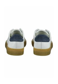 Sneaker bianche in pelle con dettagli in camoscio blu navy sul tallone, suole in gomma e "SNEAKY STEVE" impressa sul retro. Design minimalista.