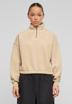 Beige fleece genser med høy krage og kvart glidelås. Har ribbede mansjetter og linning, samt en logodetalj på brystet.