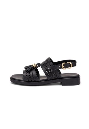 Sandalo piatto in pelle nera con motivi traforati, nappine anteriori con dettagli dorati e cinturino alla caviglia con fibbia dorata.