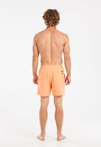 Shorts de bain pour hommes de couleur orange vif, en tissu léger, longueur genou, taille élastique avec cordon intérieur, poche arrière unique.