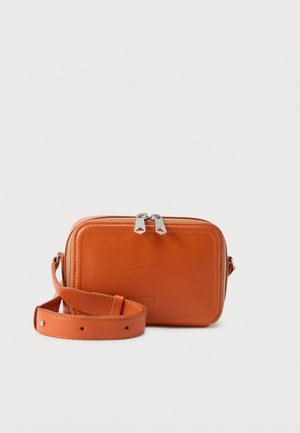 Petit sac bandoulière rectangulaire en cuir orange avec double fermeture éclair argentée et sangle réglable enroulée à côté.