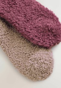 Strukturierte, plüschige Hausschuhe in dunklem Burgunderrot und hellem Beige. Mit rundem Zehenbereich, dickem, gemütlichem Material und einem weichen, flauschigen Aussehen.