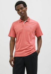 Rövid ujjú korall póló, kontrasztos fehér gallérral és egy diszkrét logóval a mellkasán. Simakészségű anyagból készült, klasszikus fazonban.