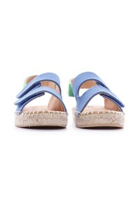 Sandales en tissu bleu avec deux larges brides, semelles en corde de style espadrille, et un accent vert à l'arrière. Design à dos ouvert.