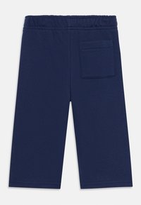 Pantalones cortos de algodón azul marino con cintura elástica, corte recto y un solo bolsillo trasero. Textura suave con un diseño sencillo.