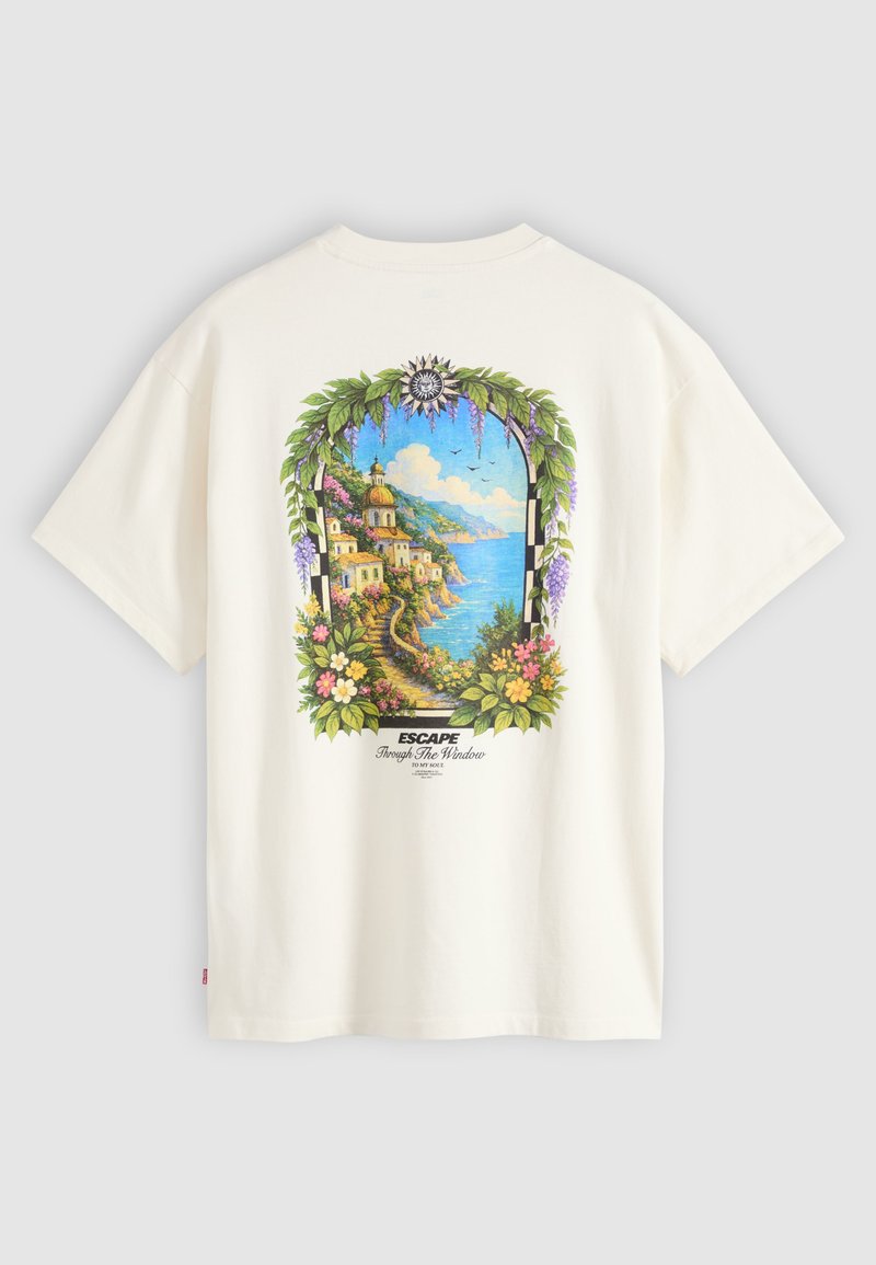White t-shirt with colorful back print of a coastal village viewed through a floral and leafy arch with text "Escape Through The Window."
