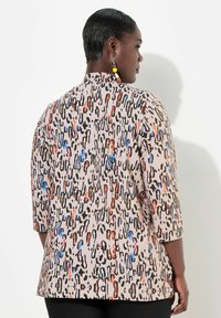 Multikleurige top met een luipaardprint in beige, voorzien van 3/4 mouwen en een hoge halslijn, gemaakt van een zachte, lichte stof.