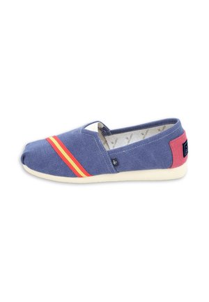 Zapatilla azul de lona tipo slip-on con rayas rojas y amarillas en la parte delantera, parche rosa en el talón, suela blanca y pequeña etiqueta lateral negra.