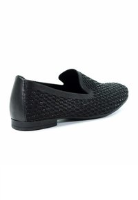 Scarpe slip-on nere con tomaia in maglia testurizzata e tacco in pelle. Presentano una suola piatta e una punta arrotondata. La superficie decorata aggiunge dettagli.