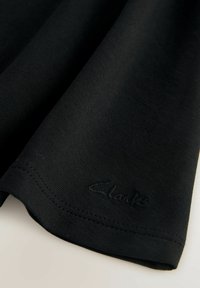 Zwart stof met een gladde textuur, voorzien van een subtiel logo "Clarks" dat nabij de zoom is gedrukt. De randen zijn netjes gestikt.