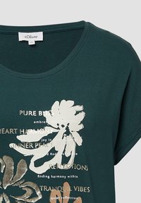 Donkergroene T-shirt met een ronde halslijn, voorzien van witte en gouden bloemenpatronen en tekst in een mix van lettertypen, gemaakt van zacht materiaal.