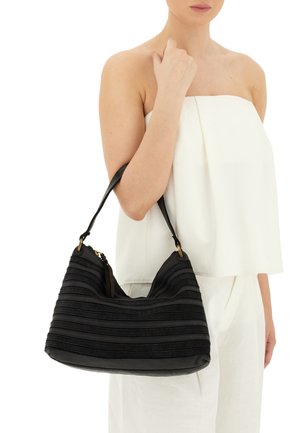 Borsa hobo nera con tessuto a righe testurizzato, dettagli in metallo dorato e forma curvata. La maniglia è lunga per un uso a spalla.