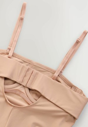 Lingerie gainante couleur chair avec des bretelles ajustables, une bande large, une fermeture à crochet et œillet, et une texture lisse avec un décolleté arrondi.