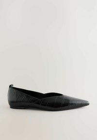 Černá plochá bota s špičatou špičkou, vyrobená z lesklého materiálu s krokodýlím vzorem. Obsahuje výřezový design a nízký podpatek.