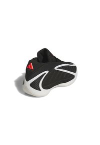 Mustat ja valkoiset urheilukengät punaisella logolla kantapäässä, teksturoitu kangas ja muotoiltu pohja, esitetty takaapäin valkoista taustaa vasten.