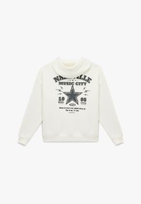 Kremowa bluza z kapturem. Posiada czarny graficzny wzór w gwiazdę oraz napis "Nashville Music City". Miękka tekstura, ściągacze przy rękawach.