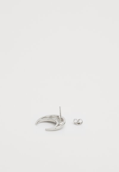 Boucle d'oreille en métal argenté en forme de croissant avec un tige, accompagnée d'un petit fermoir circulaire. Finition de surface lisse et brillante.