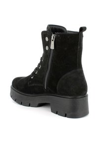 Stivaletti alla caviglia in suede nero con punta arrotondata, suola in gomma spessa, chiusura con zip laterale e dettagli metallici decorativi.