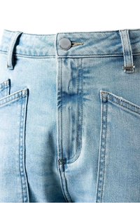 Zbliżenie na jasnoniebieskie jeansy z przodu z kieszeniami, szlufkami na pasek i metalowym guzikiem do zapięcia.