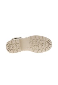 Semelle de botte beige clair avec un motif de semelle robuste, présentant de profondes rainures et des protubérances pour une traction sur diverses surfaces. Design de surface plate.