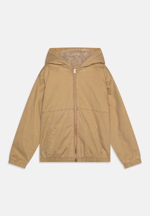 Casaco bege com capuz, fecho éclair à frente, punhos elásticos e bolsos laterais. Forro suave e exterior liso, com um corte casual.