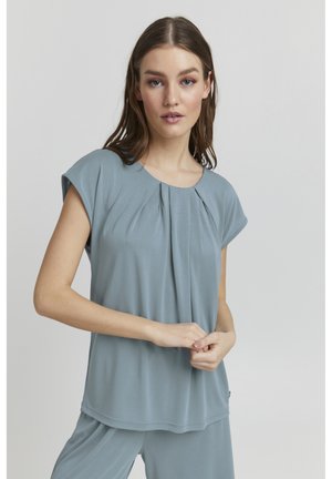 Helles blaues Kurzarmoberteil mit einem plissierten Design rund um den Ausschnitt, das eine glatte, weiche Textur und eine lockere Passform aufweist.