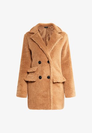 Bēšas krāsas, divrindīgs mākslīgā kažokādas mētelis ar ieliektām malām, sānu kabatām, melniem pogām un mīkstu, strukturētu audumu.