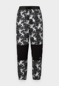 Black camo sweatpants with a drawstring waist, featuring a pixelated pattern in gray and white, and black panel accents at the knees.