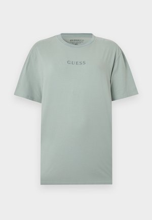 Világoszöld rövid ujjú póló "GUESS" felirattal a mellkason, szürke színben, kerek nyakkivágással és normál szabással.