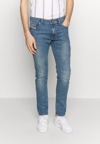 Light blue slim-fit jeans made of denim, featuring a classic five-pocket design, subtle fading, and a zip fly with button closure.