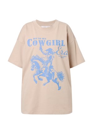 Béžové oversized tričko vyrobené z bavlny, s modrou grafikou kovboje na koni a textem "já v mé COWGIRL éře." Krátké rukávy.