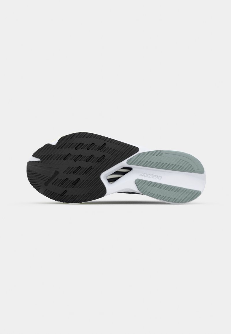 Czarny i biały bieżnik sportowego obuwia z teksturowanej gumy dla lepszej przyczepności, z jasnoszarymi akcentami i nowoczesnym, smukłym designem.