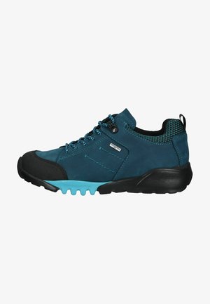 Chaussure de randonnée en vert foncé avec un capuchon en caoutchouc noir et une outsole turquoise flexible. Présente une doublure en maille texturée et des lacets bleus.